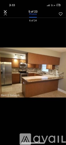 A kitchen with brown cabinets and a stone backsplash.