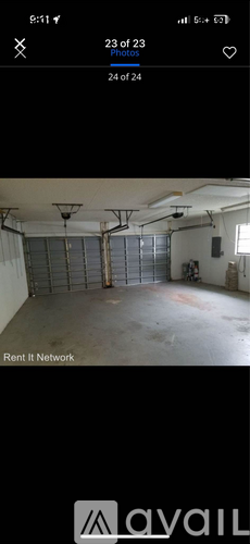 A spacious garage with a high ceiling and multiple hanging lights.