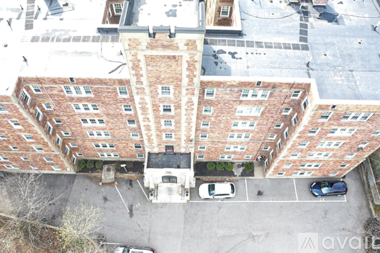 An aerial view of a large brick building with a parking lot in front.