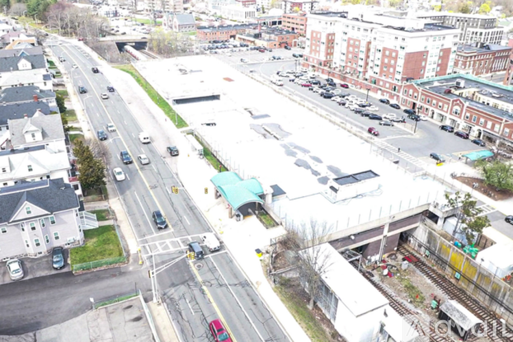 A busy intersection with cars and a train track.