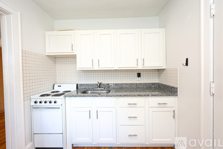 A kitchen with white cabinets and a granite countertop.