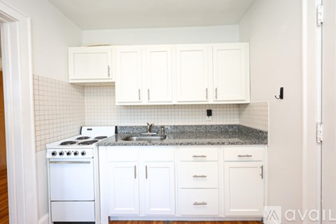 A kitchen with white cabinets and a granite countertop.