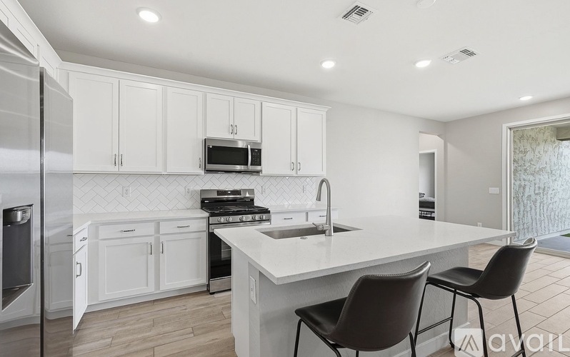 A kitchen with white cabinets and a black countertop.