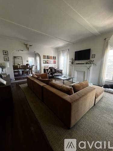 A living room with a large couch and a television mounted on the wall.