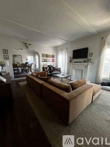 A living room with a large couch and a television mounted on the wall.