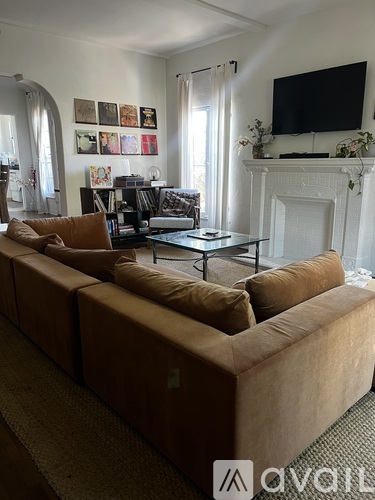 A living room with a large couch and a fireplace.