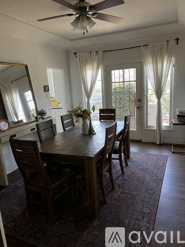 A dining room with a wooden table and chairs.