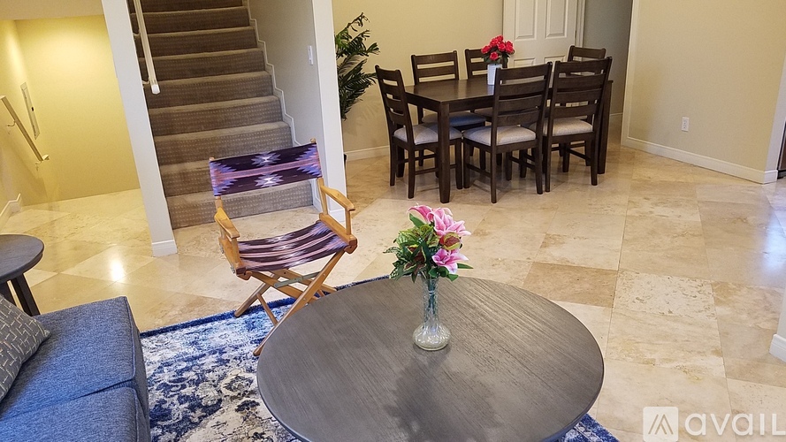 A dining room with a round table and chairs.