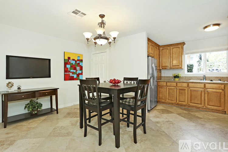 A kitchen with a table and chairs in the middle.