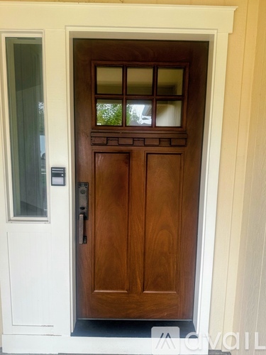 A brown door with a glass window above it.