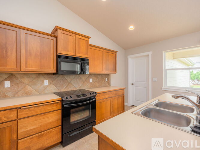 A kitchen with wooden cabinets and a black oven.