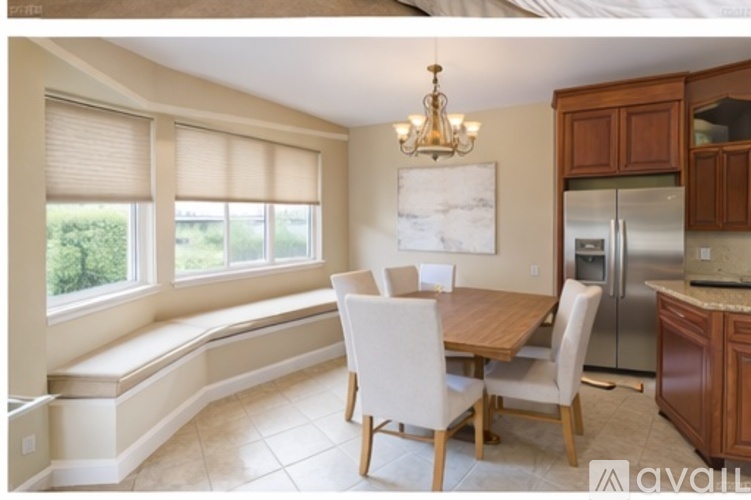 A kitchen with a table and chairs and a fridge.