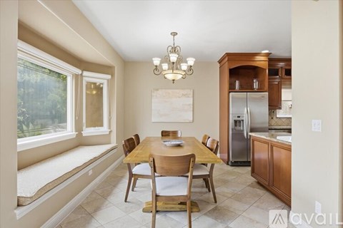 A kitchen with a table and chairs and a fridge.