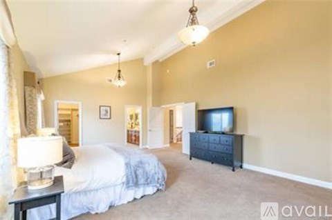 A bedroom with a large bed and a television.