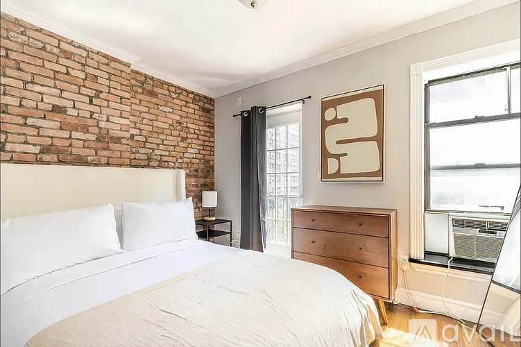 A bedroom with a brick wall and a large bed.