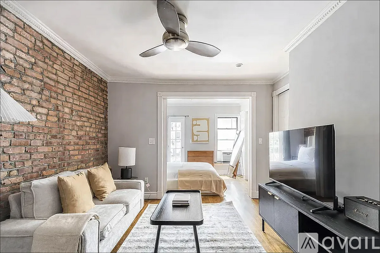 A living room with a brick wall and a television.