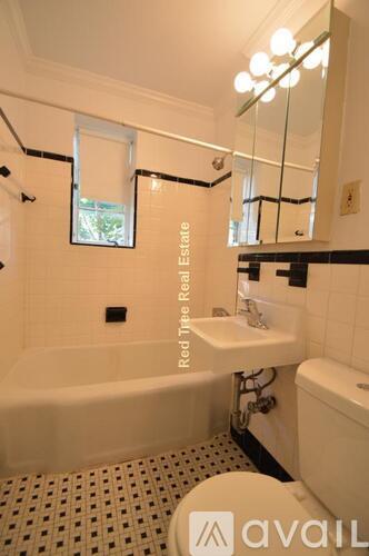 A bathroom with a tub, sink and mirror.