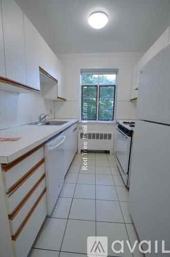 A kitchen with white cabinets and appliances is available for rent.