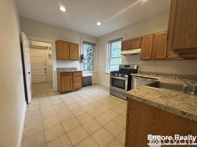 A kitchen with wooden cabinets and a granite countertop.