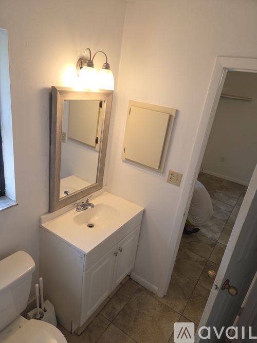 A bathroom with a sink, mirror, and toilet.
