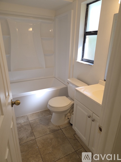 A white bathroom with a toilet, sink and tub.