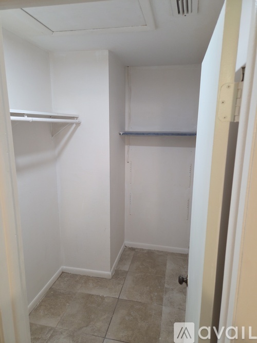 A small, empty room with a tiled floor and a door on the right.