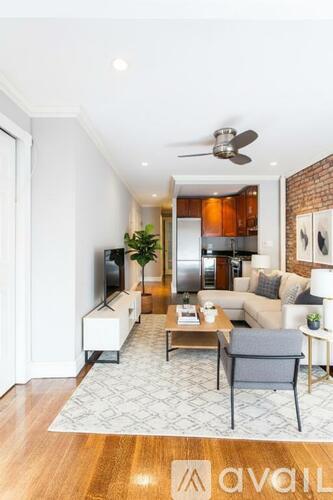 A living room with a grey couch, a white coffee table, and a television.