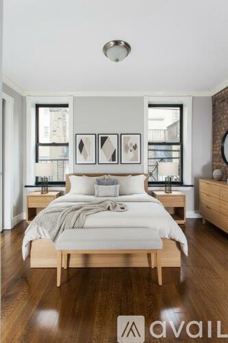 A bedroom with a bed, nightstands, and pictures on the wall.