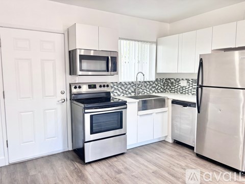 A kitchen with white cabinets and stainless steel appliances.