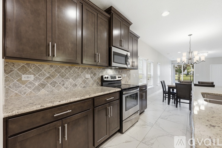 A kitchen with brown cabinets and a tile backsplash.
