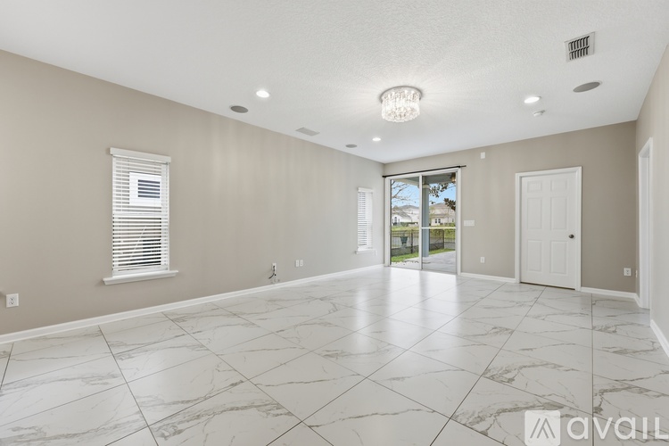 A spacious room with a marble floor and a ceiling light.
