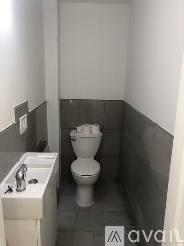 A white toilet sits next to a sink in a small bathroom.