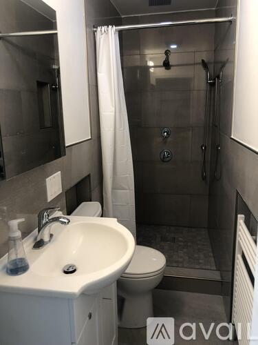 A bathroom with a white sink and toilet.