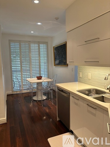 A kitchen with a table and chairs by a window.