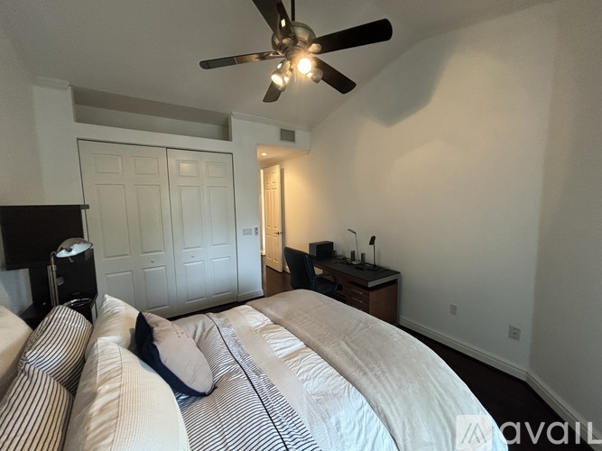A bedroom with a large bed and a ceiling fan.