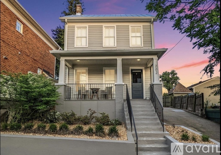 A house with a front yard and a staircase leading to the entrance.