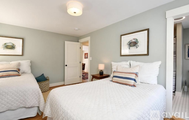 A bedroom with two beds and a painting on the wall.