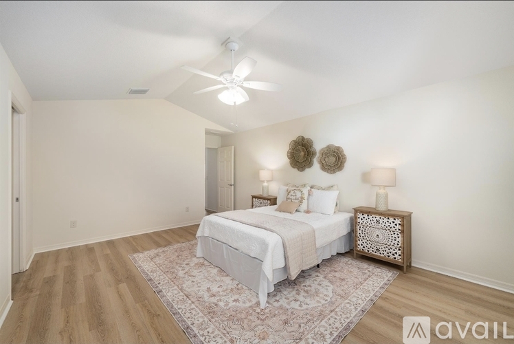 A bedroom with a bed, two lamps, and a rug.