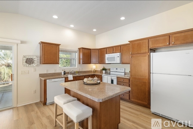 A kitchen with wooden cabinets and a granite countertop.