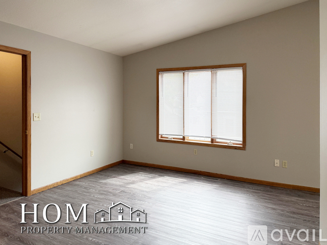 A room with a window and wooden flooring is available for rent.