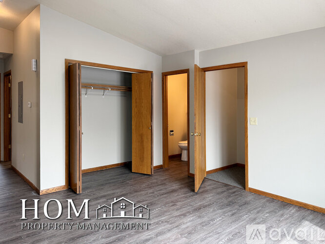 A room with a white wall and a wooden door.