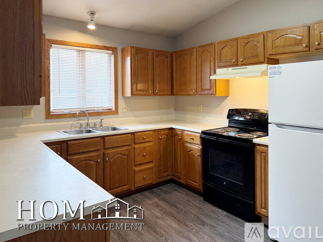 A kitchen with wooden cabinets and a white refrigerator.