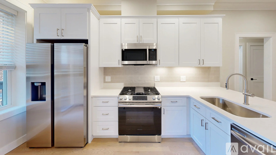 A kitchen with white cabinets and stainless steel appliances.
