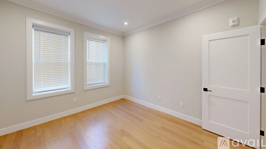 A room with wooden flooring and a white door.