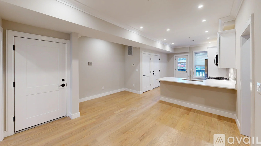 A spacious room with wooden floors and white walls.