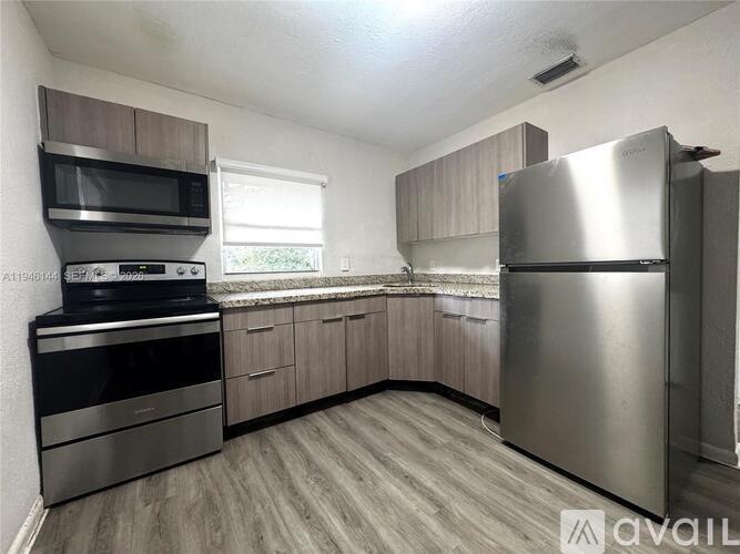 A kitchen with a stainless steel refrigerator, oven, and microwave.