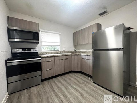 A kitchen with a stainless steel refrigerator, oven, and microwave.