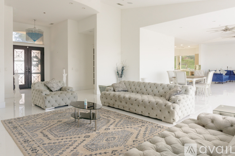 A living room with a white sofa and a glass coffee table.