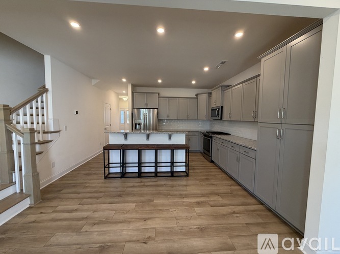A spacious kitchen with wooden flooring and a central island.