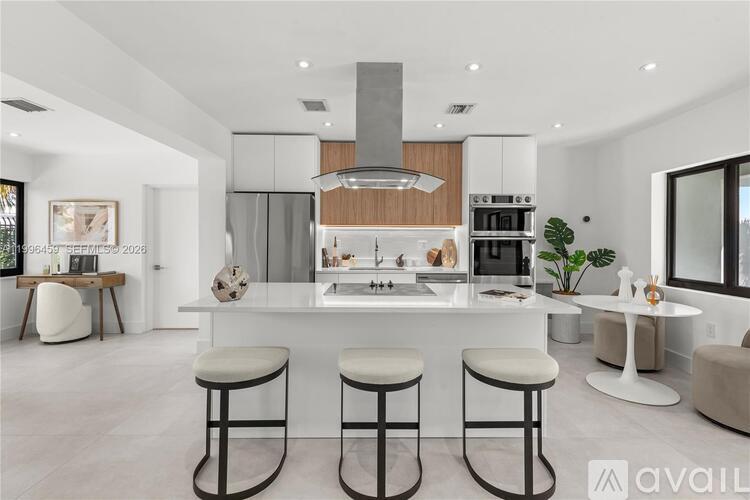 A modern kitchen with a bar stool in front of it.